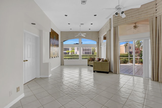 unfurnished living room featuring baseboards, visible vents, ceiling fan, and light tile patterned floors