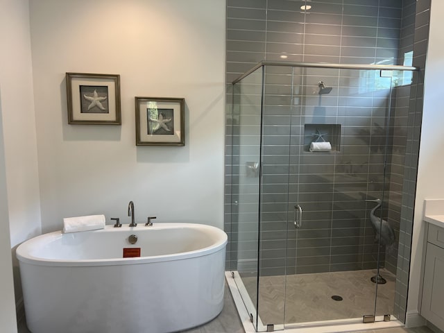 130 SE Palma St, Port Saint Lucie, FL 34984 - full bathroom featuring a soaking tub, a stall shower, and vanity