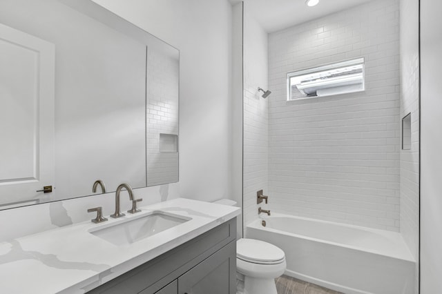 130 SE Palma St, Port Saint Lucie, FL 34984 - bathroom featuring toilet, vanity, bathing tub / shower combination, and wood finished floors