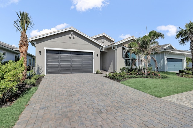 130 SE Palma St, Port Saint Lucie, FL 34984 - ranch-style house with stucco siding, an attached garage, decorative driveway, and a front yard