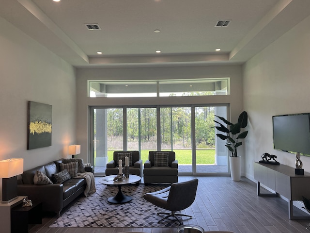 130 SE Palma St, Port Saint Lucie, FL 34984 - living room with a towering ceiling, wood finished floors, a raised ceiling, recessed lighting, and baseboards