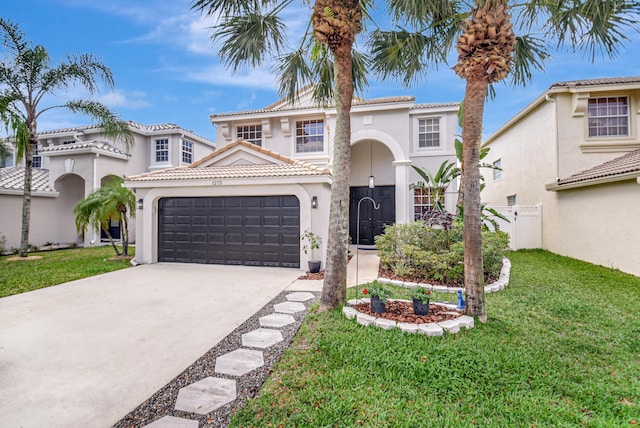mediterranean / spanish house with stucco siding, a garage, concrete driveway, and a front yard