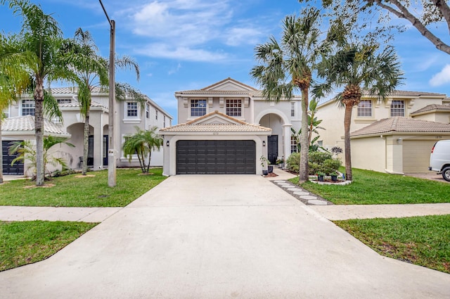 mediterranean / spanish-style house featuring a front lawn, driveway, stucco siding, and a tile roof