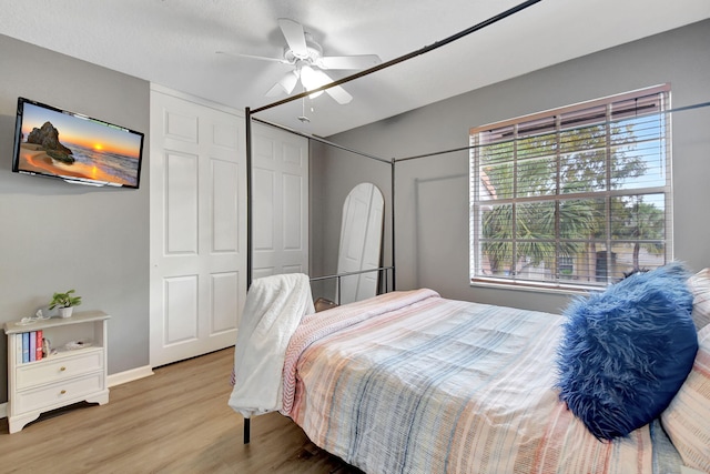 bedroom featuring baseboards, ceiling fan, and wood finished floors