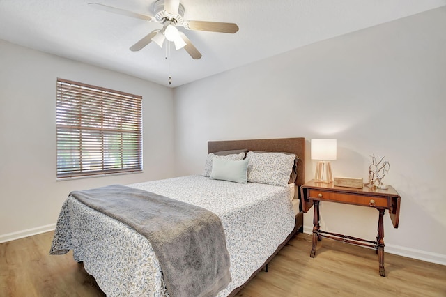 bedroom featuring light wood finished floors, baseboards, and a ceiling fan