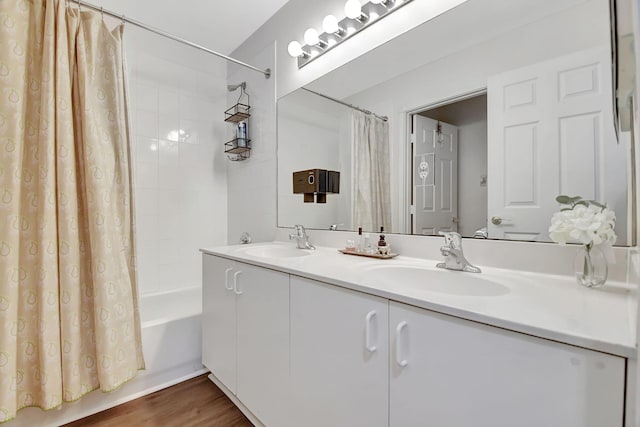 full bathroom featuring double vanity, a sink, shower / bath combo, and wood finished floors