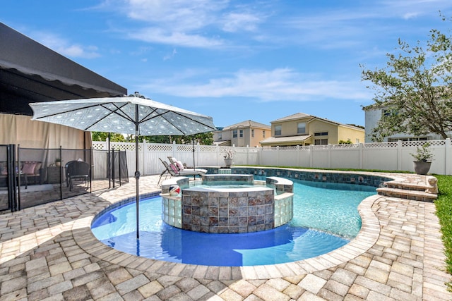 view of swimming pool with a patio, a fenced backyard, and a pool with connected hot tub