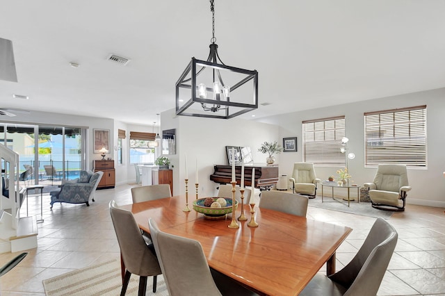 dining room with light tile patterned floors, a notable chandelier, baseboards, and visible vents