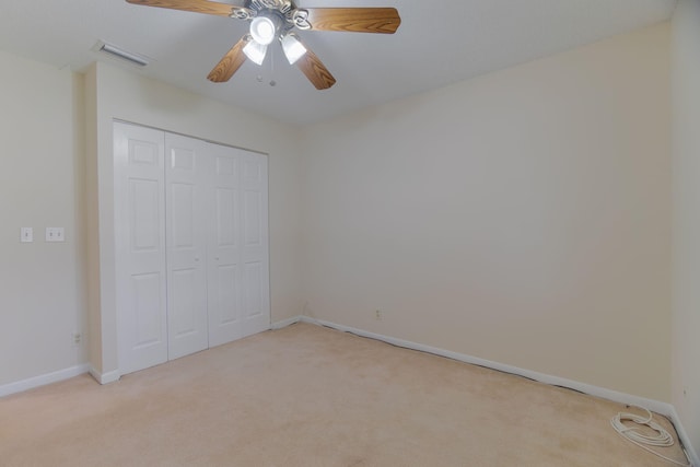 unfurnished bedroom featuring light carpet, visible vents, and a closet