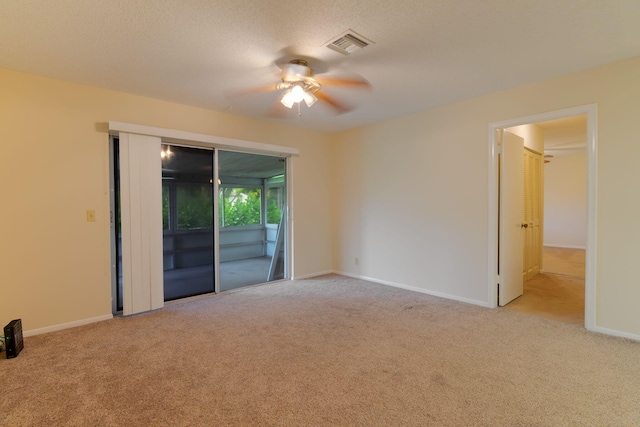 unfurnished room featuring a ceiling fan, visible vents, and carpet