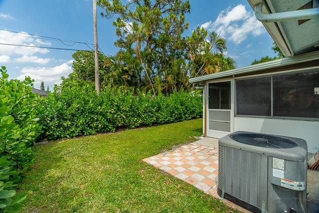 view of yard featuring a patio area, a sunroom, and central AC unit