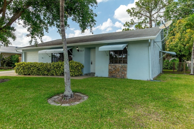 single story home with stucco siding, an attached garage, stone siding, and a front lawn