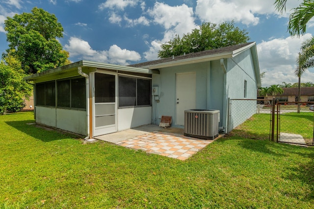 rear view of house featuring cooling unit, a sunroom, fence, and a lawn