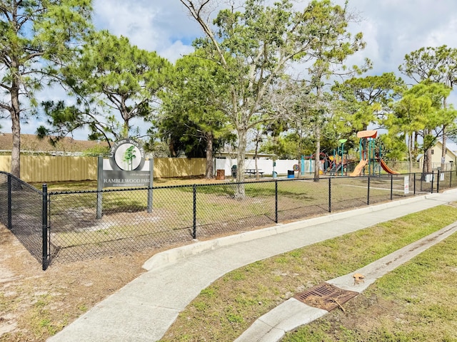 surrounding community with fence and a yard