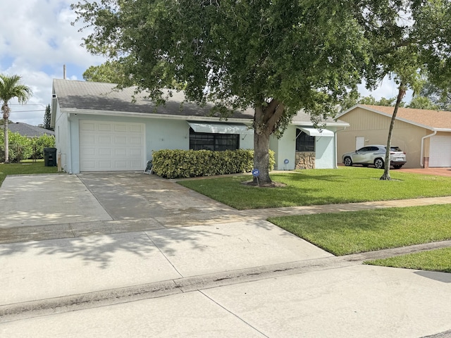 ranch-style home with concrete driveway, stucco siding, a front yard, and a garage
