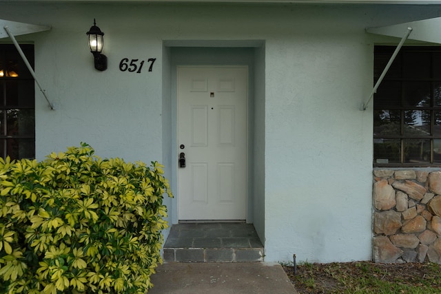 property entrance with stucco siding