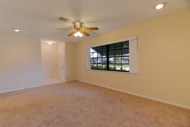 spare room with baseboards, a ceiling fan, carpet flooring, and visible vents