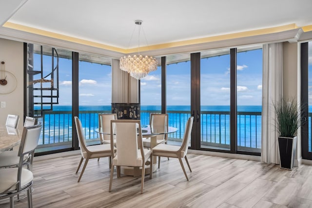 9900 S Ocean Dr Unit 1601, Jensen Beach, FL 34957 - dining space featuring a wall of windows, wood finished floors, a water view, and a notable chandelier