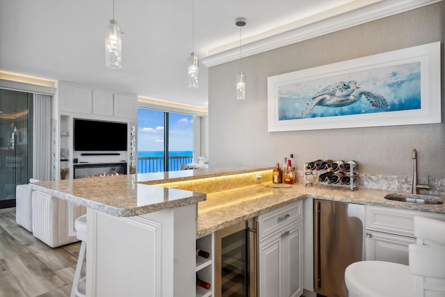 9900 S Ocean Dr Unit 1601, Jensen Beach, FL 34957 - kitchen with refrigerator, a sink, a peninsula, light stone countertops, and wine cooler