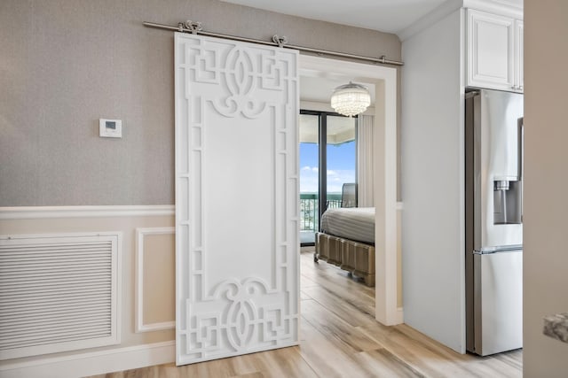 9900 S Ocean Dr Unit 1601, Jensen Beach, FL 34957 - corridor with light wood-style flooring and a chandelier