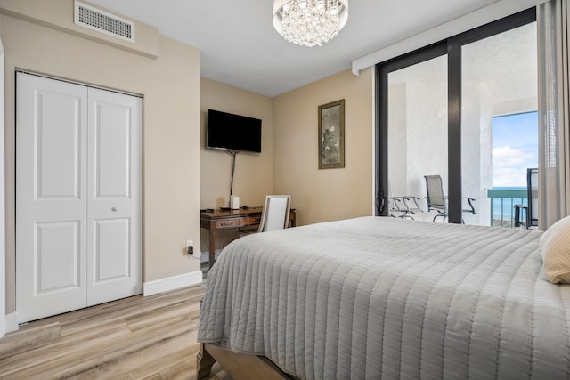 9900 S Ocean Dr Unit 1601, Jensen Beach, FL 34957 - bedroom featuring baseboards, visible vents, an inviting chandelier, light wood-style floors, and a closet