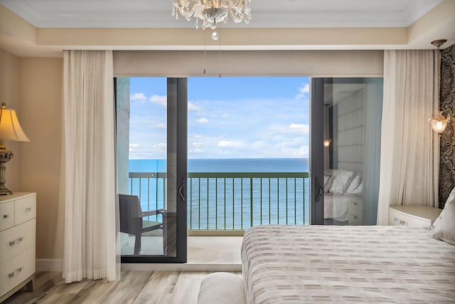 9900 S Ocean Dr Unit 1601, Jensen Beach, FL 34957 - bedroom with a water view, access to exterior, a chandelier, wood finished floors, and crown molding