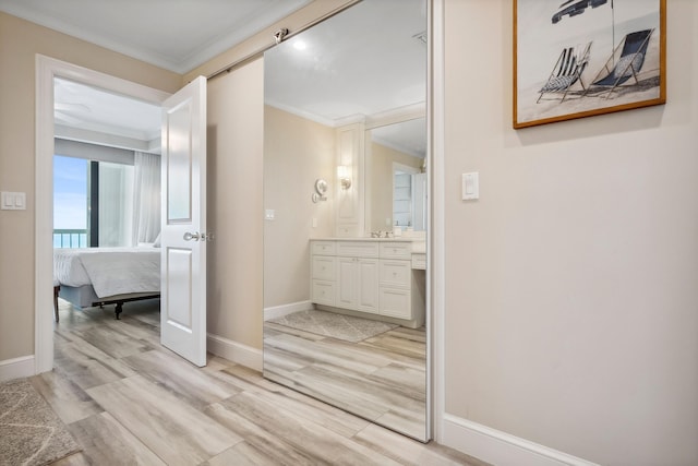 9900 S Ocean Dr Unit 1601, Jensen Beach, FL 34957 - ensuite bathroom featuring crown molding, wood finished floors, ensuite bathroom, vanity, and baseboards