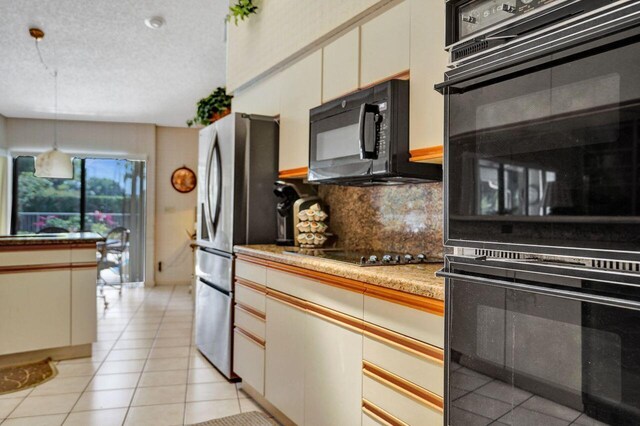 13179 Camero Way, Palm Beach Gardens, FL 33418 - kitchen featuring black appliances, tasteful backsplash, decorative light fixtures, light tile patterned flooring, and cream cabinetry