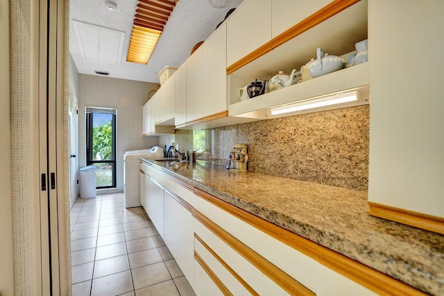 13179 Camero Way, Palm Beach Gardens, FL 33418 - kitchen featuring washer / clothes dryer, white cabinets, light tile patterned flooring, open shelves, and a sink