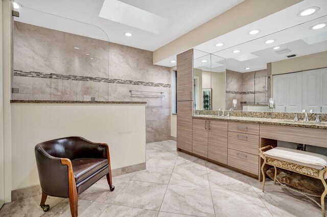 13179 Camero Way, Palm Beach Gardens, FL 33418 - full bath with a walk in shower, vanity, a skylight, recessed lighting, and tile walls