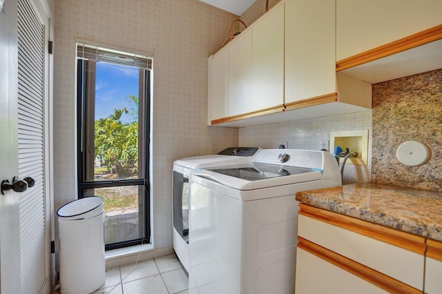 13179 Camero Way, Palm Beach Gardens, FL 33418 - laundry area featuring cabinet space, washing machine and dryer, light tile patterned floors, healthy amount of natural light, and tile walls