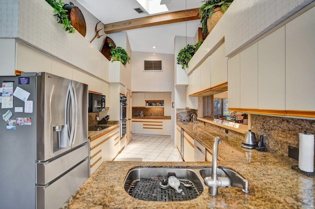 13179 Camero Way, Palm Beach Gardens, FL 33418 - kitchen featuring appliances with stainless steel finishes, backsplash, a towering ceiling, a sink, and light stone countertops