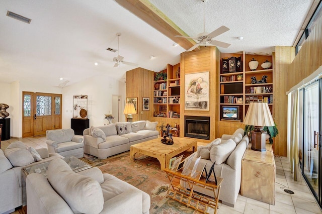 13179 Camero Way, Palm Beach Gardens, FL 33418 - living room featuring a ceiling fan, vaulted ceiling, built in shelves, wooden walls, and light tile patterned floors