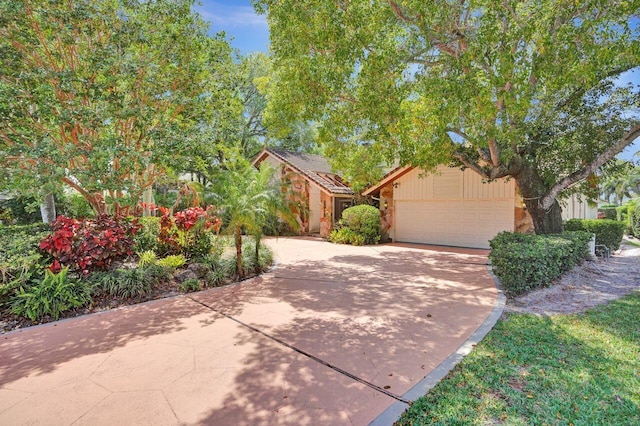 13179 Camero Way, Palm Beach Gardens, FL 33418 - obstructed view of property with concrete driveway, an attached garage, and stone siding