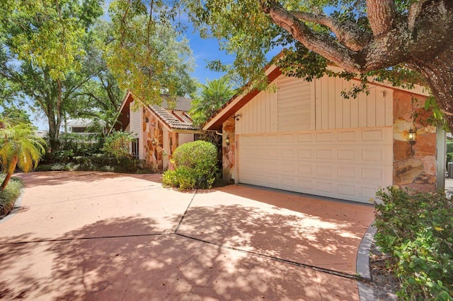 13179 Camero Way, Palm Beach Gardens, FL 33418 - view of front of home with stone siding, driveway, and a tile roof