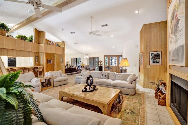 13179 Camero Way, Palm Beach Gardens, FL 33418 - living area with ceiling fan, beamed ceiling, wooden walls, light tile patterned floors, and a large fireplace