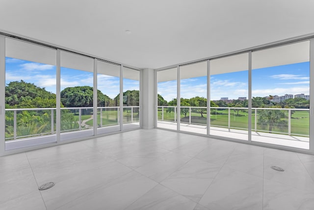210 SE Mizner Blvd Unit 301, Boca Raton, FL 33432 - tiled spare room featuring a wall of windows and view of scattered trees