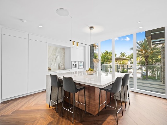 210 SE Mizner Blvd Unit 301, Boca Raton, FL 33432 - kitchen with modern cabinets, white cabinets, plenty of natural light, a breakfast bar area, and recessed lighting