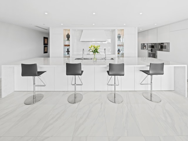 210 SE Mizner Blvd Unit 301, Boca Raton, FL 33432 - kitchen featuring modern cabinets, white cabinetry, premium range hood, a sink, and light countertops