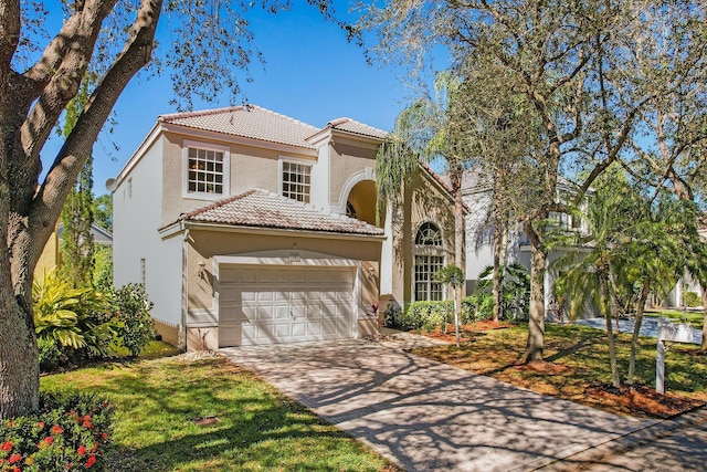 mediterranean / spanish-style home featuring a garage, stucco siding, a tile roof, and driveway