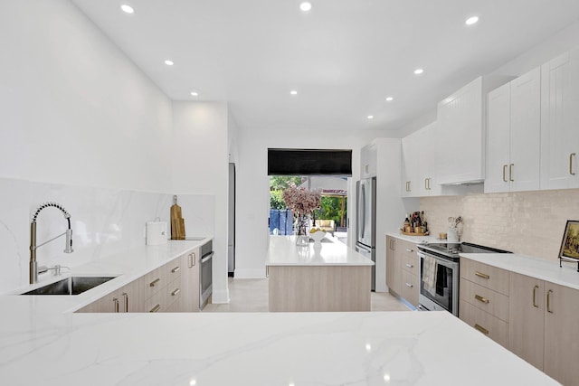 kitchen with recessed lighting, appliances with stainless steel finishes, backsplash, a sink, and a center island