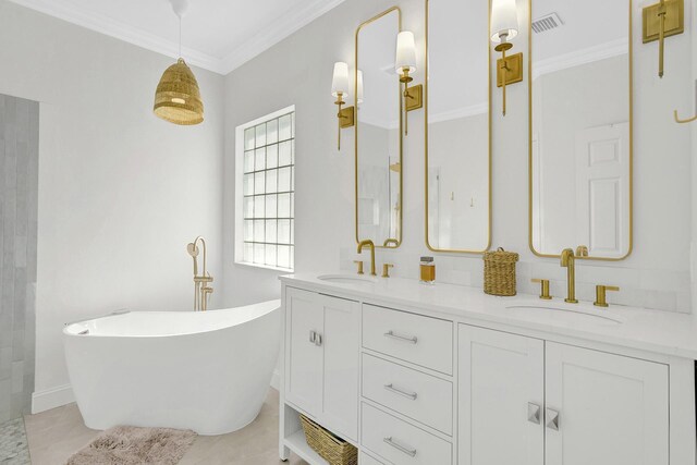 full bathroom with a freestanding tub, ornamental molding, and a sink