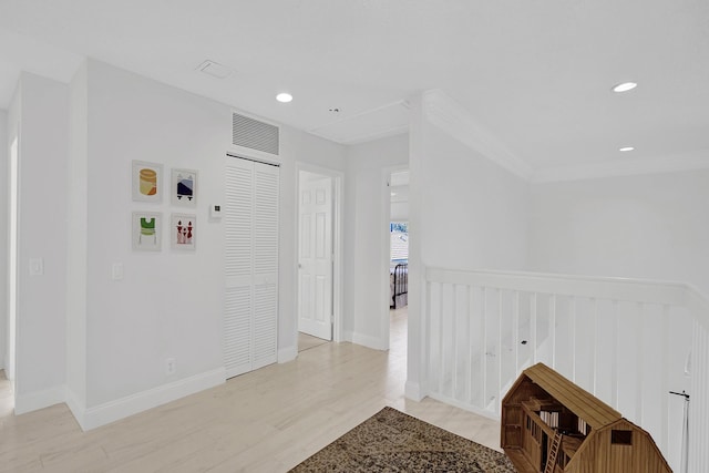 corridor featuring recessed lighting, an upstairs landing, light wood-type flooring, baseboards, and ornamental molding