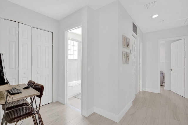 corridor featuring visible vents, light wood-type flooring, recessed lighting, and baseboards