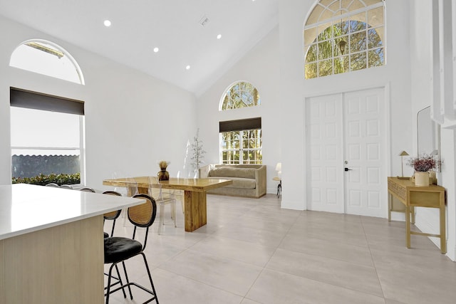 entryway featuring recessed lighting, light tile patterned flooring, high vaulted ceiling, and baseboards