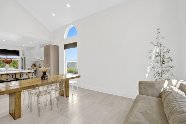 living room with baseboards, high vaulted ceiling, a healthy amount of sunlight, and recessed lighting