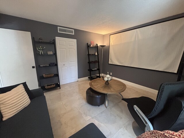 1705 Presidential Way N Unit B101, West Palm Beach, FL 33401 - cinema with a textured ceiling, baseboards, and light marble finish floors