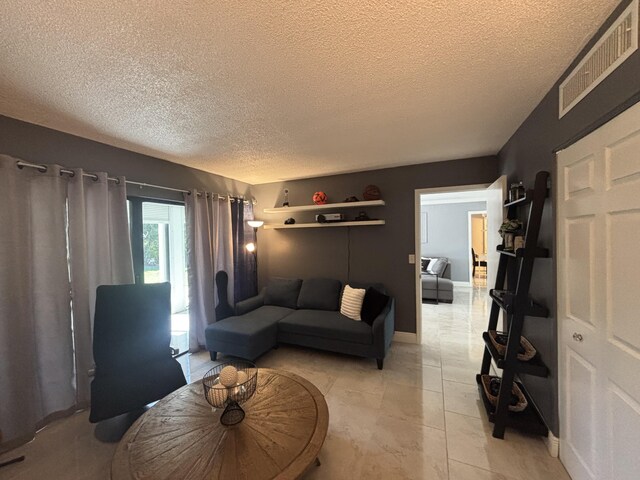 1705 Presidential Way N Unit B101, West Palm Beach, FL 33401 - living area with a textured ceiling and baseboards