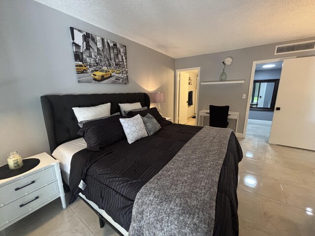 1705 Presidential Way N Unit B101, West Palm Beach, FL 33401 - bedroom with a textured ceiling and ensuite bath