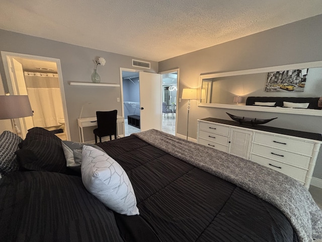 1705 Presidential Way N Unit B101, West Palm Beach, FL 33401 - bedroom featuring a walk in closet, a textured ceiling, and ensuite bathroom